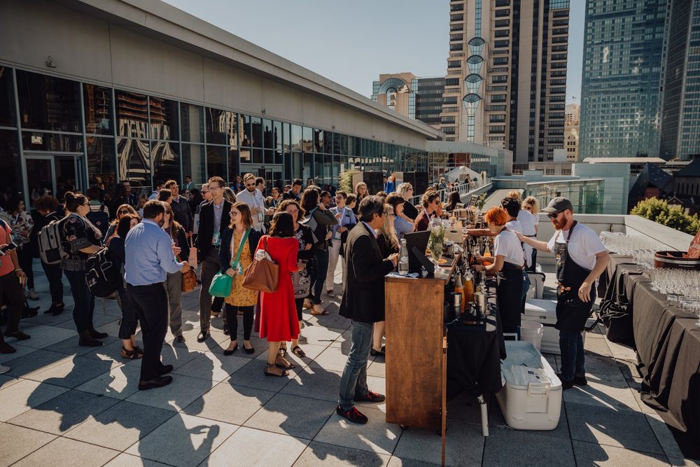 Attendees mingling at the rooftop bar between sessions