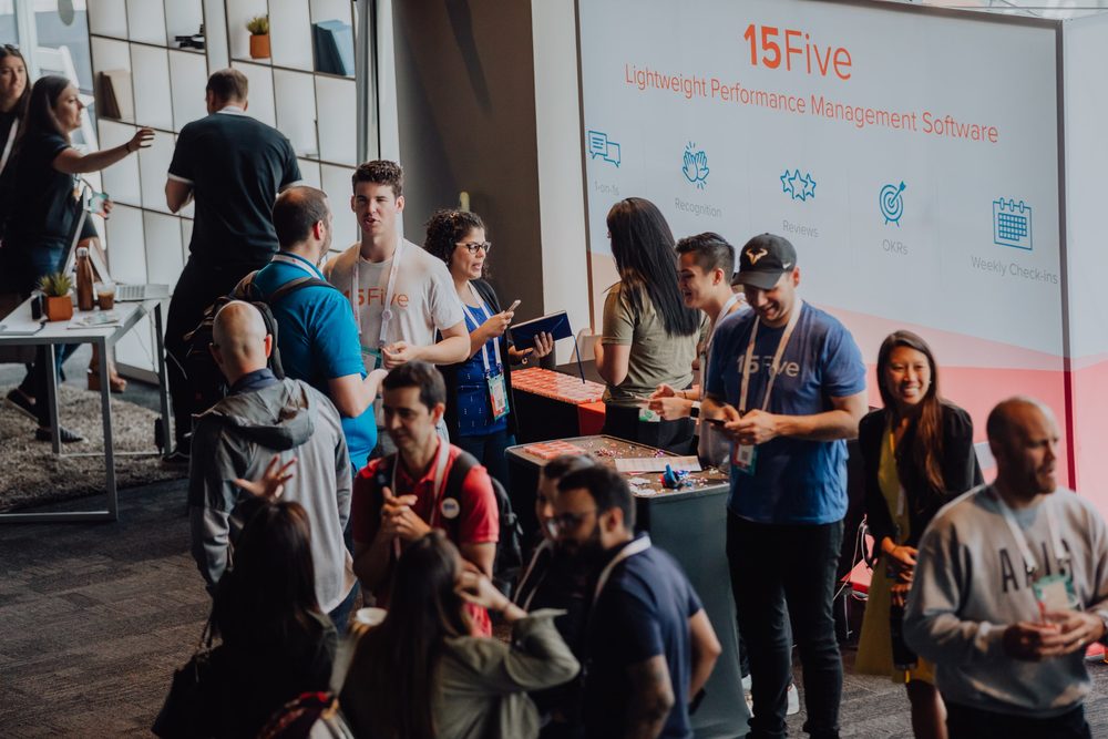 Attendees talking at the 15Five sponsor booth