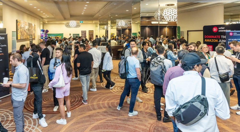 A crowded expo hallway with attendees networking between sponsor booths
