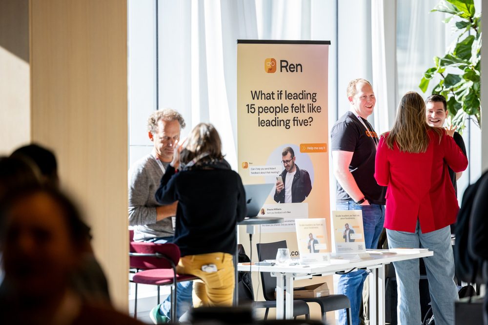 Attendees talking at a sponsor table