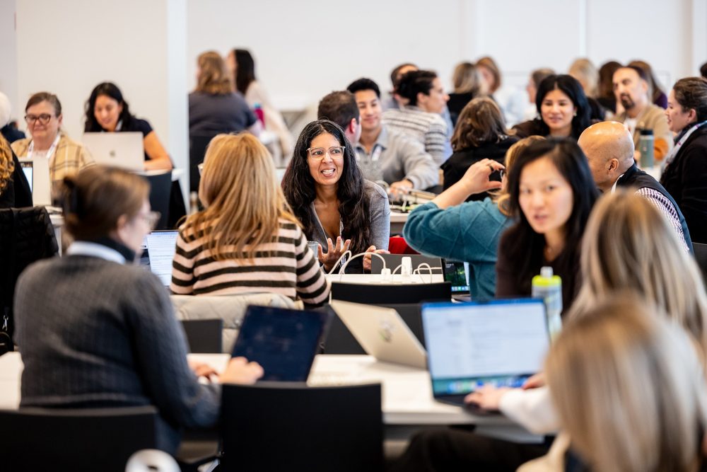 Attendees in conversation at workshop tables